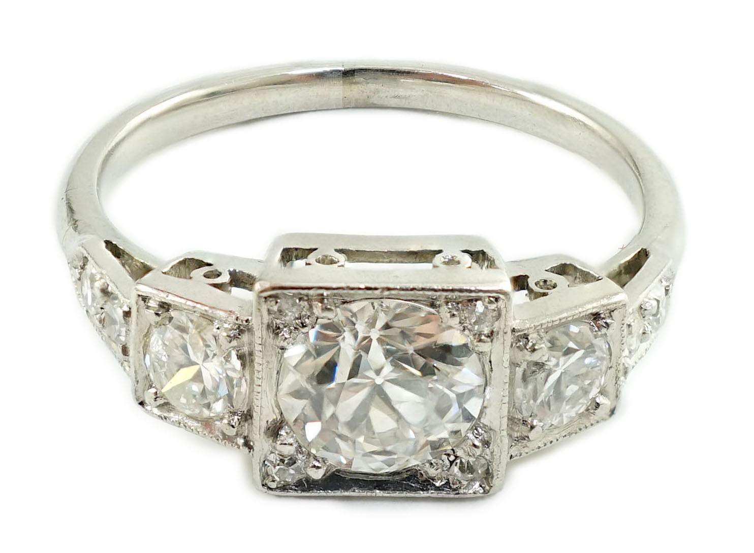 A platinum and millegrain set three stone diamond ring, with diamond set shoulders